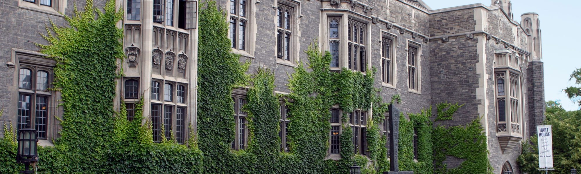 Student eating and sitting in front of Hart House